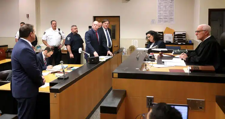 In the April court hearing, prosecutors updated the judge in the case, Timothy Mazzei, right, on their recent progress in turning over evidence to Mr. Brown, center.Credit...Pool photo by James Carbone